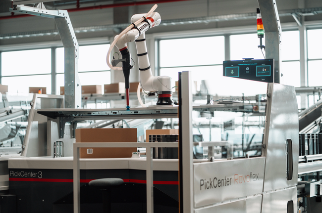 Les commandes sont préparées sur six postes de picking haute performance, dont l’un est équipé d’un robot RovoFlex.<br>
  Crdit photo : TGW Logistics