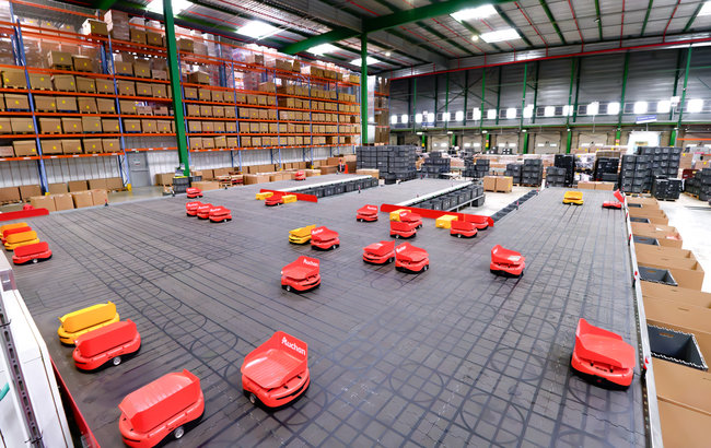D&eacute;ploy&eacute;e sur le site logistique de Villab&eacute; op&eacute;r&eacute; par GEODIS, la solution con&ccedil;ue par Sequence Robotics combine robots mobiles, syst&egrave;mes Put to Light et pilotage logiciel.<br>
                            Cr&eacute;dit photo : Auchan.